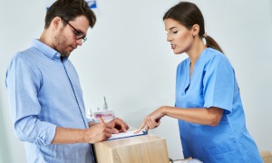 A man paying the cost of cosmetic dentistry